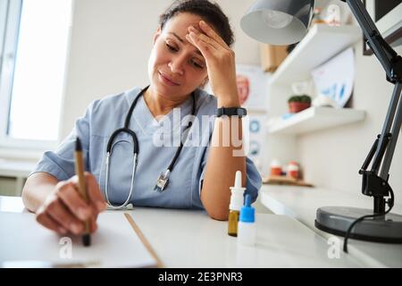 Frustrierte Ärztin hat Kopfschmerzen Stockfoto