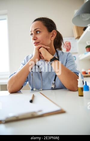 Der lateinamerikanische Therapeut sitzt tief in Gedanken Stockfoto