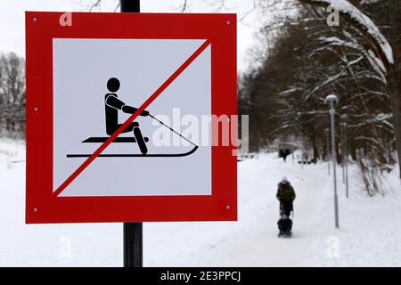 Warnschild, das Rodeln im verschneiten Park verbietet. Sicherheit von Kindern während der Winterferien Stockfoto