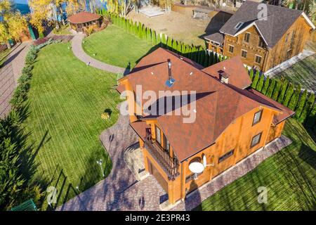 Luftaufnahme über dem Kopf erhöhte Ansicht des schönen Luxus großen modernen Holzhauses. Holzhaus Villa mit grünem Rasen Garten und gepflasterten Fußweg zu Stockfoto