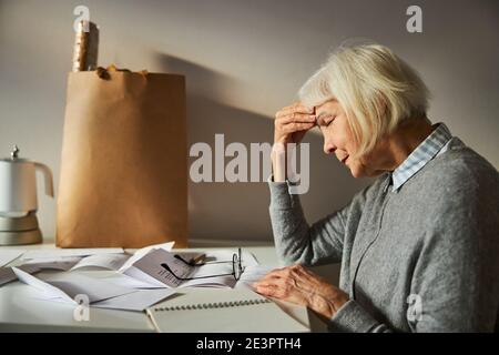 Rentnerin leidet unter schweren Kopfschmerzen Stockfoto