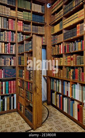 Die geheime Tür des Bücherregals führt zur hinteren Treppe im Antiquariat Auguste Blaizot in Paris, Frankreich. Stockfoto