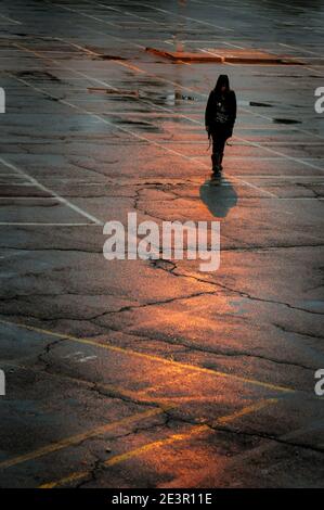 Walking Schatten einer unerkannten Person, die in den Straßen nach Regen Stockfoto