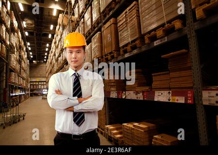Orientalischer Geschäftsmann, der in einem Lager steht, hochwertiges Foto Stockfoto