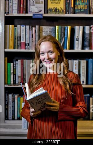 GREAT BRITAN / London / Buchhandlungen / schöne Frau, die ein Buch in einer Buchhandlung liest. Stockfoto