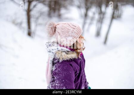 Kleines Mädchen genießen Winteraktivitäten auf dem Schnee Stockfoto