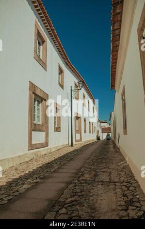 Fassade von alten weiß getünchten Häusern und niedlichen Fenstern in Kopfsteinpflaster Gasse, an einem sonnigen Tag in Marvão. Ein erstaunliches mittelalterliches befestigtes Dorf in Portugal. Stockfoto