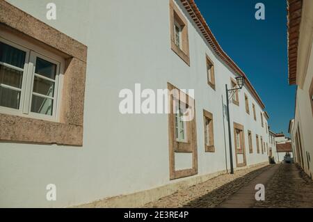 Fassade von alten weiß getünchten Häusern und niedlichen Fenstern in Kopfsteinpflaster Gasse, an einem sonnigen Tag in Marvão. Ein erstaunliches mittelalterliches befestigtes Dorf in Portugal. Stockfoto