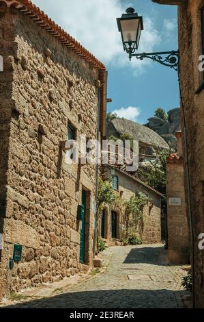 Fassade von alten Steinhäusern mit Metallwandleuchte, in verlassener Gasse bei Monsanto. Ein süßes und eigenartiges historisches Dorf in Portugal. Stockfoto
