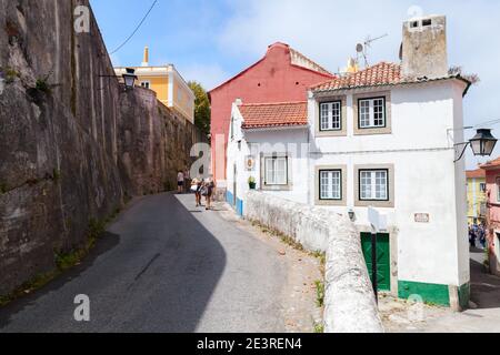 Sintra, Portugal - 14. August 2017: Blick auf die Straße mit alten Wohnhäusern der Altstadt von Sintra. Gewöhnliche Menschen gehen die enge Straße entlang Stockfoto