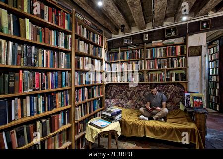 FRANKREICH / Iie-de-France / Paris /Mann liest Buch bei Shakespeare and Company in Paris . Stockfoto