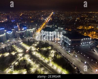 Luftaufnahme Nachtansicht auf Freedom Svobody Square in Beleuchtung Lichter Zirkus. Derzhprom und Karazina National University in Charkiw Stadtzentrum, Ukraine Stockfoto