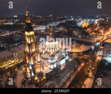 Heilige Verkündigungskathedrale beleuchtet im Winter verschneite Nachtlichter. Luftaufnahme Charkiw Stadt orthodoxe Kirche Wahrzeichen , Ukraine. Seitenansicht aus der Luft. Stockfoto