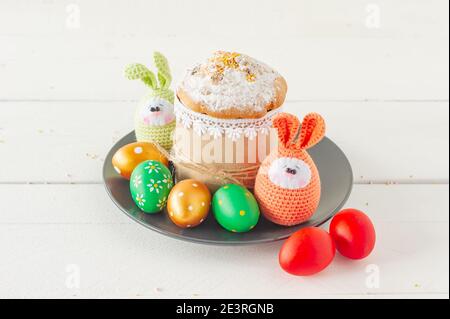 Arrangement Dekoration Frohe Ostern Urlaub Hintergrundkonzept. Ostercakeon ein Teller mit handgefertigten gestrickten Eiern. Pastellfarben. Stockfoto