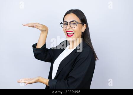 Schöne Geschäftsfrau gesturing mit Händen zeigt große und große Größe Zeichen, Maßnahme Symbol. Lächelnd. Messkonzept. Stockfoto
