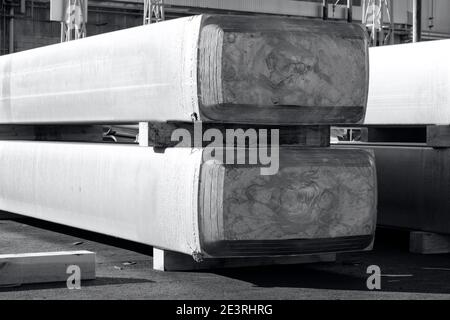 Große Aluminium-Barren in einer Hofgießerei gestapelt, Rohmaterial in einer heißen Mühle verarbeitet werden. Foto in schwarz und weiß mit bläulichen Ton Stockfoto