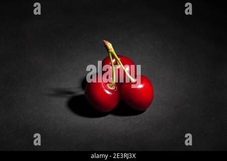 Rote Kirsche auf schwarzem Hintergrund Stockfoto