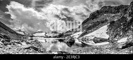 Österreich. Dramatische Bergbilder im Monochrom vom Schwarzsee in den Bergen der Zillertaler Alpen im österreichischen Tirol in der Nähe der berühmten Berliner Hütte, die hier zu den Gipfeln des Schwarzensteins und den Gipfeln des Südtirols blickt. Stockfoto