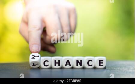 Hand dreht Würfel und ändert den Ausdruck '1. Chance' in '2. Chance'. Stockfoto