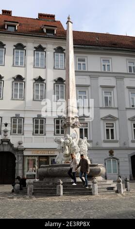 Touristen am berühmten Brunnen der drei Flüsse von Krain In Ljubljana, die als Robba-Brunnen bekannt ist Stockfoto