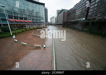 Manchester, Großbritannien, 20. Januar 2021. Ein Mitglied der Öffentlichkeit steht am Fluss Irwell im Zentrum von Manchester, nachdem Greater Manchester das letzte Gebiet wurde, das einen schweren Zwischenfall deklariert, da große Teile von Zentral- und Nordengland in den Weg des Sturms Christoph geraten waren. Kredit: Jon Super/Alamy Live Nachrichten. Stockfoto