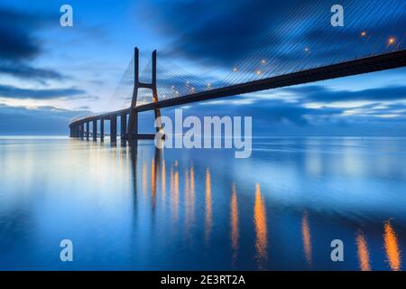 Hintergrund mit nachtlicht auf der Lissabon-Brücke. Die Vasco da Gama Brücke ist ein Wahrzeichen und eine der längsten Brücken der Welt. Urbane Landschaft Stockfoto