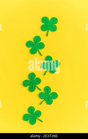 St. Patricks Day Hintergrund. Einfach minimalistisches Design mit grünem Kleeblatt. Kleeblätter isoliert auf gelbem Hintergrund. Symbol von Irland. Glück w Stockfoto