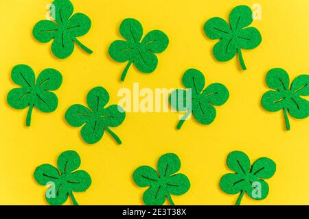 St. Patricks Day Hintergrund. Einfach minimalistisches Design mit grünem Kleeblatt. Kleeblätter isoliert auf gelbem Hintergrund. Symbol von Irland. Glück w Stockfoto