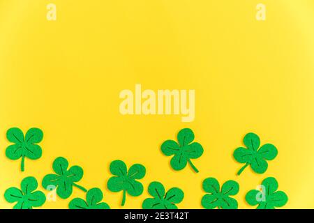 St. Patricks Day Hintergrund. Einfach minimalistisches Design mit grünem Kleeblatt. Kleeblätter isoliert auf gelbem Hintergrund. Symbol von Irland. Glück w Stockfoto