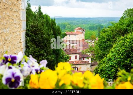 Aubeterre sur Dronne (Frankreich). Seit 1993 als "eines der schönsten Dörfer Frankreichs" gelistet. Verschwommene Stiefmütterchen Blumen im Vordergrund. Stockfoto