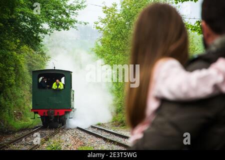 Ankunft der Dampfeisenbahn. Attraktion für Kinder und Eltern. Azpeitia, Spanien. Vater hält Tochter. Stockfoto