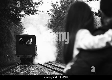 Ankunft der Dampfeisenbahn. Attraktion für Kinder und Eltern. Azpeitia, Spanien. Vater hält Tochter. Historisches Foto in Schwarzweiß Stockfoto