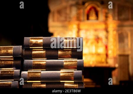 Gebetsbücher und verschwommener Altar im Hintergrund. Religionskonzept. Selektiver Fokus. Stockfoto