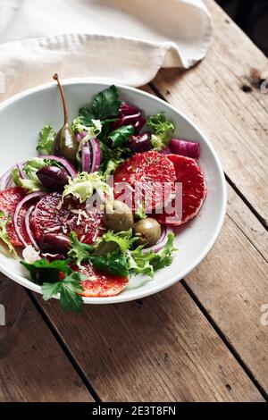 Sizilianischer Orangensalat. Salat mit Blutorange, roten Zwiebeln und Oliven. Stockfoto