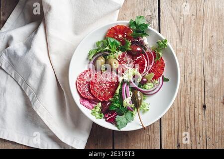 Sizilianischer Orangensalat. Salat mit Blutorange, roten Zwiebeln und Oliven. Stockfoto