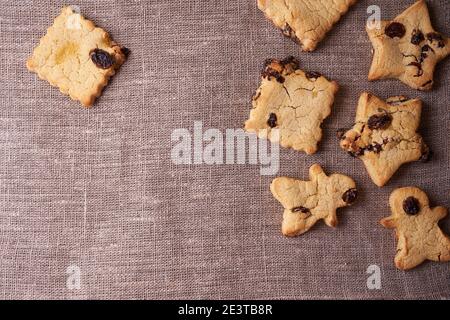 Schokoladenkekse auf Leinenserviette in den verschiedenen Formen glutenfrei, laktosefrei, zuckerfrei, gesundes Dessert mit Rosinen mit Kopierfläche Stockfoto