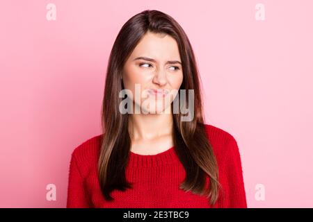 Foto-Porträt von unzufrieden angewidert junge Mädchen mit geraden braun Haare Grimacing Blick auf Seite isoliert auf rosa Hintergrund Stockfoto