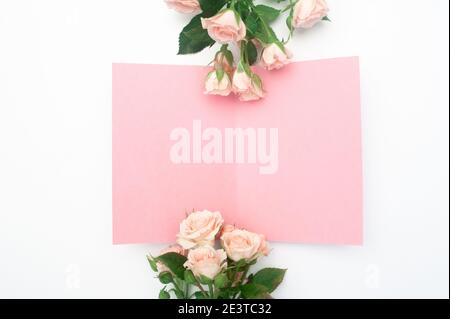 Hochzeit oder Geburtstag Mock up Szene. Leeres offenes Blatt Papier mit Platz für Text für Grußkarte. Bouquet von rosa Rosen auf weißem Hintergrund. Flach Stockfoto