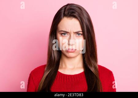 Foto-Porträt von launisch verärgert Mädchen mit geraden braunen Haaren Blick auf Kamera trägt Strickpullover isoliert auf rosa Pastell Farbiger Hintergrund Stockfoto