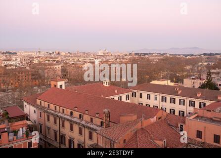 Blick bei Sonnenuntergang über den Dächern des historischen Stadtteils Trastevere über den Tiber hinunter ins Zentrum von Rom, Italien Stockfoto