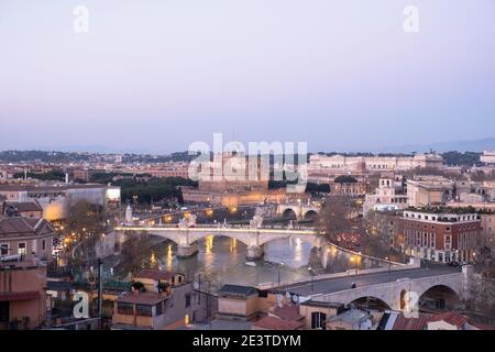 Blick hinunter auf Brücken über den Tiber und die Engelsburg, Rom, Italien, von Trastevere, bei Sonnenuntergang. Stockfoto