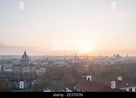 Blick auf das Zentrum von Rom, Italien, von Trastevere, über den Tiber, bei Sonnenaufgang. Stockfoto