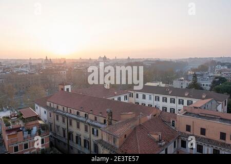 Blick auf den Sonnenaufgang über die Dächer von Trastevere über den Tiber hinunter ins Zentrum von Rom, Italien, in Richtung des Denkmals von Vittorio Emanuele II Stockfoto