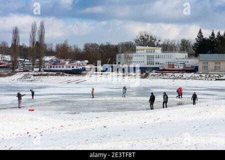 Brno, Tschechische Republik - 17. Januar 2021: Gefrorener Brünner Stausee, Menschen, die auf dem gefrorenen Stausee spazieren. Der Damm liegt am Fluss Svratka. Ort für Erholung, und ein Stockfoto