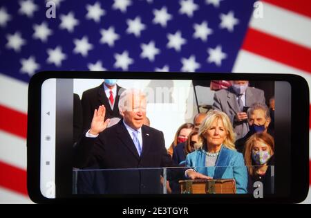 Ukraine. Januar 2021. In diesem Foto Illustration Joe Biden nimmt den Eid während seiner Amtseinführung als 46. Präsident der Vereinigten Staaten in Washington, DC auf einer Video-Übersetzung in facebook auf einem Smartphone-Bildschirm vor der US-Flagge angezeigt. Kredit: SOPA Images Limited/Alamy Live Nachrichten Stockfoto
