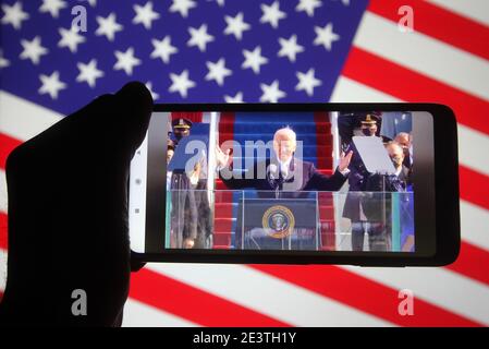 Ukraine. Januar 2021. In diesem Foto Illustration Joe Biden spricht während seiner Amtseinführung als 46. Präsident der Vereinigten Staaten in Washington, DC auf einer Video-Übersetzung in facebook auf einem Smartphone-Bildschirm vor der US-Flagge angezeigt. Kredit: SOPA Images Limited/Alamy Live Nachrichten Stockfoto