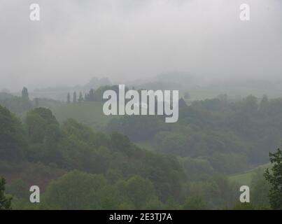 Neblige Morgenlandschaft im französischen Baskenland. Traditionelles Bauernhaus und Hügel versteckt im Nebel. Stockfoto