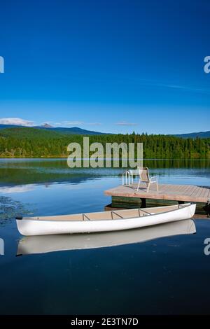 Dutch Lake an an an Autumn Morning, Clearwater, British Columbia Kanada. , Kanu in ruhigem Wasser mit Berg reflectiosn im See Stockfoto