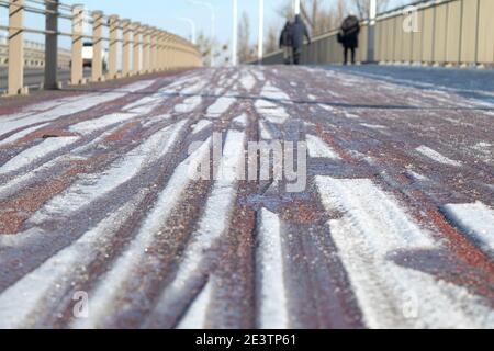 Eis und Schnee auf den Straßen und Gehwegen. Schneefall und Eis in der Stadt. Nahaufnahme Stockfoto