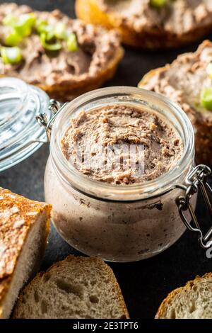 Leberpastete im Glas auf schwarzem Tisch. Stockfoto